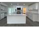 Bright kitchen featuring an island, stainless steel appliances, and white cabinets at 793 N Kentucky Ave, Umatilla, FL 32784