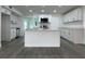 Bright kitchen featuring an island, stainless steel appliances, and white cabinets at 793 N Kentucky Ave, Umatilla, FL 32784