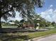 A fenced-in community playground with multiple slides and play structures for children to enjoy outdoor activities at 793 N Kentucky Ave, Umatilla, FL 32784