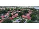 An aerial view shows many houses with red roofs and tall trees surrounding them, with a large lake in the background at 8057 Marcella Dr, Orlando, FL 32836