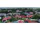 An aerial view shows many homes with different colored roofs surrounded by trees and a lake in the background at 8057 Marcella Dr, Orlando, FL 32836