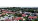 An aerial view shows many homes with red roofs and tall trees surrounding them, with a lake in the background at 8057 Marcella Dr, Orlando, FL 32836