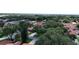 An aerial view shows homes with tile roofs surrounded by green trees and a view of the nearby lake at 8057 Marcella Dr, Orlando, FL 32836
