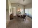 Open dining area with vaulted ceilings, a glass table and a view into the kitchen at 8057 Marcella Dr, Orlando, FL 32836