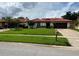 Attractive single-story home featuring a red tile roof and green lawn, exuding curb appeal at 8057 Marcella Dr, Orlando, FL 32836