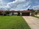 Charming single-story home with a well-manicured lawn, red tile roof and a two car garage at 8057 Marcella Dr, Orlando, FL 32836