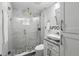 Bathroom with modern glass shower, white vanity, and decorative stone mosaic flooring at 911 Mendoza Ln, Kissimmee, FL 34758