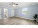 Bright bedroom featuring wood-look tile flooring, a ceiling fan, and an ensuite bathroom at 911 Mendoza Ln, Kissimmee, FL 34758