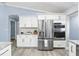 Stainless steel refrigerator and built-in ovens complement white kitchen at 911 Mendoza Ln, Kissimmee, FL 34758