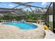 Sparkling pool with waterfall feature, enclosed screen and ample seating for entertaining, surrounded by a beautiful patio at 911 Mendoza Ln, Kissimmee, FL 34758