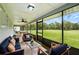 This screened patio has comfortable seating with large windows and views overlooking the home's large, green backyard at 911 Mendoza Ln, Kissimmee, FL 34758