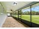 This screened patio features tile floors and large windows overlooking the home's spacious backyard at 911 Mendoza Ln, Kissimmee, FL 34758