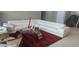 Elegant living room with a plush white sectional sofa and a unique glass coffee table on a red rug at 9414 Haber Ct, Orlando, FL 32827