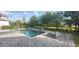 A backyard pool features a jacuzzi, modern water features, and a tiled lounge area with landscaped greenery all around at 9414 Haber Ct, Orlando, FL 32827