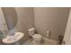 Powder room featuring a white sink, a round mirror, and neutral walls at 9414 Haber Ct, Orlando, FL 32827