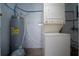 Laundry area featuring a stacked washer and dryer and a water heater at 1009 S Ivey Ln, Orlando, FL 32811