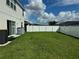 Well-maintained backyard with lush green grass, white vinyl fence, and sliding glass doors to the home at 1016 Cascade Dr, Davenport, FL 33837
