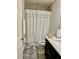 Bathroom with modern white shower curtain, vanity, and toilet, creating a fresh and clean space at 1016 Cascade Dr, Davenport, FL 33837