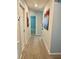 Hallway with neutral paint and carpet leads to other rooms in the home, accentuated with artwork at 1016 Cascade Dr, Davenport, FL 33837