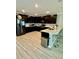 Modern kitchen with dark cabinets, stainless steel appliances, and a breakfast bar with seating at 1016 Cascade Dr, Davenport, FL 33837