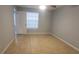 Well-lit bedroom with tile flooring, neutral paint, and a window offering natural light at 1023 S Hiawassee Rd # 4017, Orlando, FL 32835
