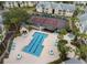 Aerial view of a community pool, hot tub, and tennis courts with many tropical plantings surrounding the area at 1023 S Hiawassee Rd # 4017, Orlando, FL 32835