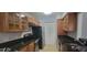 Kitchen showcases wood cabinetry, black countertops, and modern stainless steel appliances with a convenient layout at 1023 S Hiawassee Rd # 4017, Orlando, FL 32835