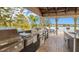 Outdoor kitchen features several stainless steel barbecue grills with a sink, counter space, and picnic tables by the lake at 1023 S Hiawassee Rd # 4017, Orlando, FL 32835