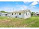 Rear view of a cozy home with a large, grassy backyard, showcasing the property's outdoor space at 120 & 0 8Th Wahneta W St, Winter Haven, FL 33880