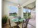 Bright breakfast nook features a glass table, and sliding glass doors to the outdoor lanai and water views at 1225 Bella Cara Ct # 1, Davenport, FL 33896
