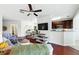 A cozy living room with hardwood floors, ceiling fan, TV, and an adjacent kitchen area at 1225 Bella Cara Ct # 1, Davenport, FL 33896