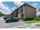Exterior view of building with parking, screened balconies, mature landscaping, and accessible parking at 139 Oyster Bay Cir # 200, Altamonte Springs, FL 32701