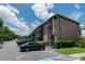 Exterior view of building with parking, screened balconies, mature landscaping, and accessible parking at 139 Oyster Bay Cir # 200, Altamonte Springs, FL 32701