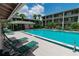 Community pool with lounge chairs, mature palms and lush green landscaping surrounding multi-story buildings at 139 Oyster Bay Cir # 200, Altamonte Springs, FL 32701