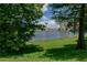 Picturesque water view framed by trees, showcasing lush green grass and a water tower in the distance at 139 Oyster Bay Cir # 200, Altamonte Springs, FL 32701
