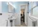 Bathroom featuring white tile, a pedestal sink, a medicine cabinet, and a blue wall paint at 1566 Providence Blvd, Deltona, FL 32725