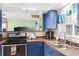 This charming kitchen features blue cabinets, a double sink, and an electric range oven at 1566 Providence Blvd, Deltona, FL 32725