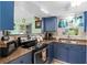 This charming kitchen features blue cabinets, a double sink, and an electric range oven at 1566 Providence Blvd, Deltona, FL 32725