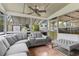 Bright sunroom showcasing a plush gray sectional sofa, tiled floors and a clear view of the backyard at 1566 Providence Blvd, Deltona, FL 32725
