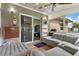 Cozy sunroom with a plush gray sofa, tiled floors, an ottoman and a view of the outdoors at 1566 Providence Blvd, Deltona, FL 32725