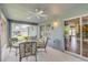 This screened patio features a ceiling fan, table with chairs, and sliding doors to the house at 157 Long Pine Dr, Deltona, FL 32725