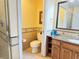 Bright bathroom featuring granite counters, wood cabinets, decorative tile, and updated fixtures at 1592 Heritage Crossing Ct # 202, Reunion, FL 34747