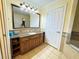 Bathroom featuring a vanity with granite countertops, wooden cabinets, and a large mirror at 1592 Heritage Crossing Ct # 202, Reunion, FL 34747