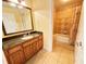Bathroom featuring granite countertop, and neutral-toned tiled shower and floors at 1592 Heritage Crossing Ct # 202, Reunion, FL 34747