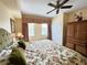 Bedroom featuring neutral walls, ceiling fan, and floral patterned bedspread at 1592 Heritage Crossing Ct # 202, Reunion, FL 34747