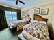 Bedroom featuring two beds with wicker headboards, floral bedding, and large window at 1592 Heritage Crossing Ct # 202, Reunion, FL 34747
