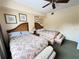 Bedroom featuring two beds with wicker headboards, floral bedding, and ceiling fan at 1592 Heritage Crossing Ct # 202, Reunion, FL 34747