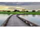 Scenic view of a golf course with a wooden bridge and clubhouse in the background at 1592 Heritage Crossing Ct # 202, Reunion, FL 34747