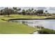 Tranquil view of a golf course with a serene lake, bunkers and lush greenery, and mature trees at 1592 Heritage Crossing Ct # 202, Reunion, FL 34747