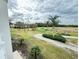 Scenic golf course view showcasing lush greens and palm trees under a cloudy sky at 1592 Heritage Crossing Ct # 202, Reunion, FL 34747